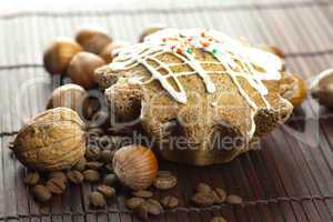 cake with icing, coffee beans and nuts lying on a bamboo mat