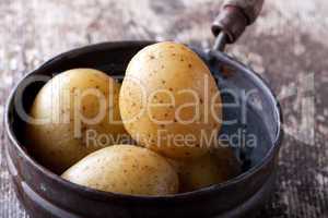 vier gekochten Kartoffeln in einem alten Topf