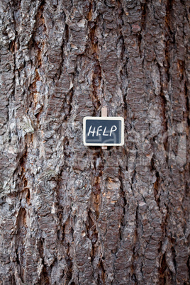 background of tree bark and blackboard with the inscription help