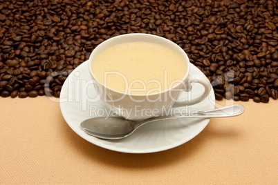 White cup of coffee and coffee beans