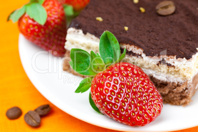 cake and strawberries lying on the orange fabric