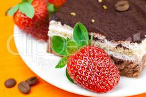 cake and strawberries lying on the orange fabric