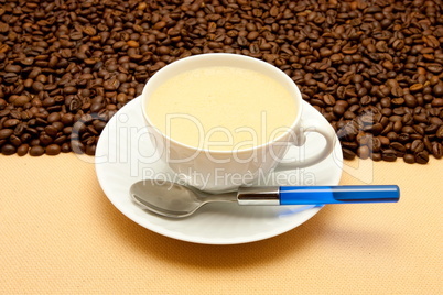 White cup of coffee and coffee beans