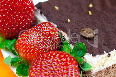 cake on a plate and strawberries lying on the orange fabric