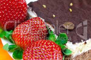 cake on a plate and strawberries lying on the orange fabric