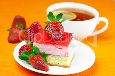 lemon tea, cake and strawberries lying on the orange fabric