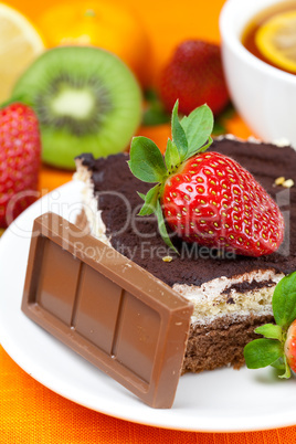 lemon tea,chocolate, kiwi,cake and strawberries lying on the ora