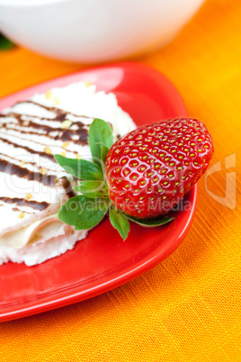 lemon tea, cake and strawberries lying on the orange fabric