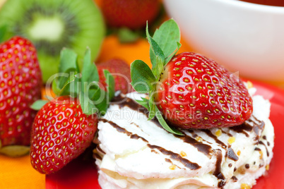 kiwi,cake and strawberries lying on the orange fabric