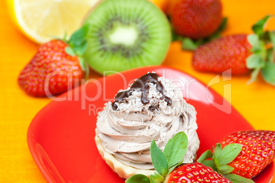 lemon,mandarin,kiwi,cake and strawberries lying on the orange fa