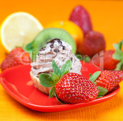 lemon,mandarin,kiwi,cake and strawberries lying on the orange fa