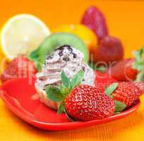 lemon,mandarin,kiwi,cake and strawberries lying on the orange fa