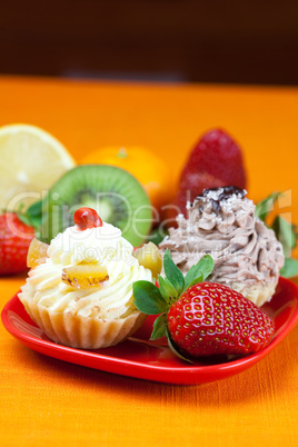 lemon,mandarin,kiwi,cake and strawberries lying on the orange fa