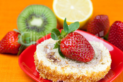 cake,kiwi,lemon and strawberries lying on the orange fabric