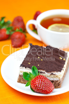 lemon tea, cake and strawberries lying on the orange fabric