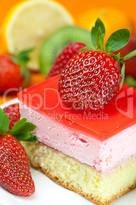 lemon tea, kiwi,cake and strawberries lying on the orange fabric