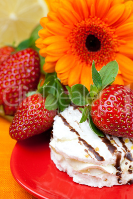 lemon ,gerbera,cake and strawberries lying on the orange fabric