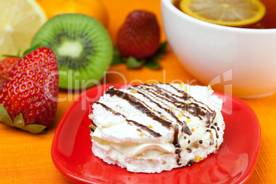 lemon tea, kiwi,cake and strawberries lying on the orange fabric