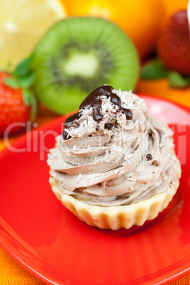 lemon,mandarin.kiwi,cake and strawberries lying on the orange fa