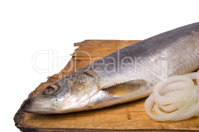 Herring with onion rings on old wooden board