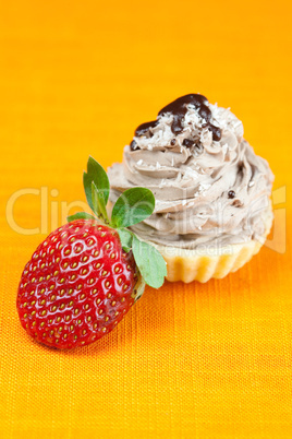 cake with cream and strawberries on the orange fabric