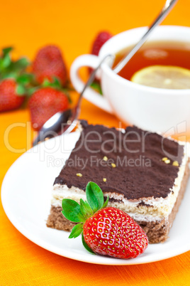 lemon tea, cake and strawberries lying on the orange fabric