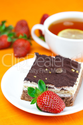 lemon tea, cake and strawberries lying on the orange fabric