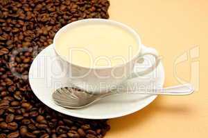 White cup of coffee and coffee beans