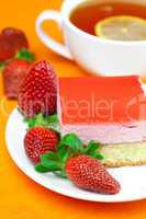 lemon tea, cake and strawberries lying on the orange fabric