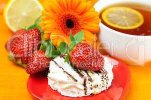 lemon tea ,lemon,gerbera,cake and strawberries lying on the oran