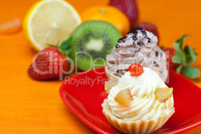 lemon,mandarin,kiwi,cake and strawberries lying on the orange fa