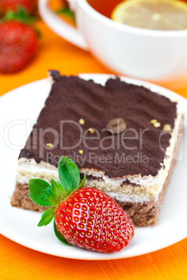 lemon tea, cake and strawberries lying on the orange fabric