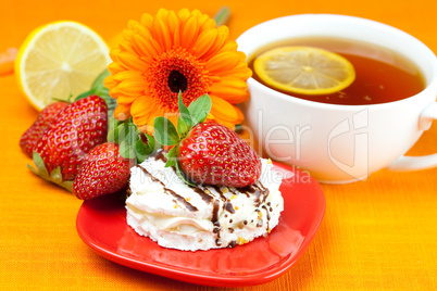 lemon tea ,lemon,gerbera,cake and strawberries lying on the oran