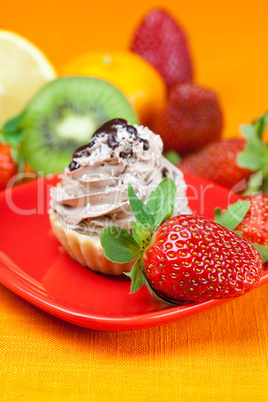 lemon,mandarin,kiwi,cake and strawberries lying on the orange fa