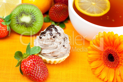 gerbera,lemon tea,mandarin,kiwi,cake and strawberries lying on t