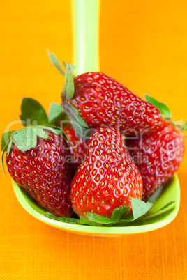 strawberries in a spoon of the orange fabric