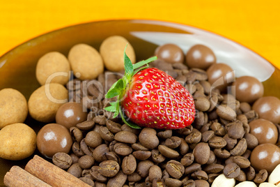 strawberries lying on a background of coffee beans, cinnamon and