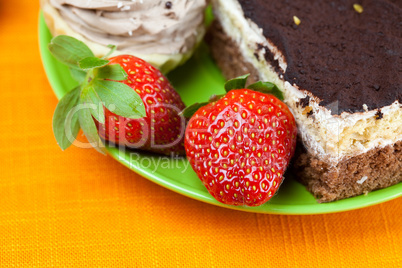 cake and strawberries lying on the orange fabric