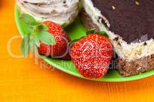 cake and strawberries lying on the orange fabric