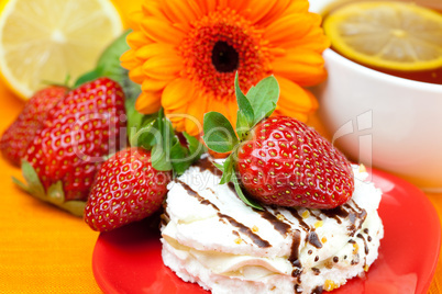 lemon tea ,lemon,gerbera,cake and strawberries lying on the oran