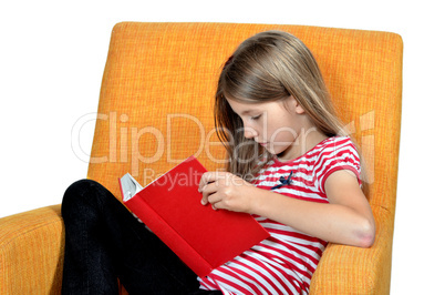 Kind ließt ein Buch im Sessel