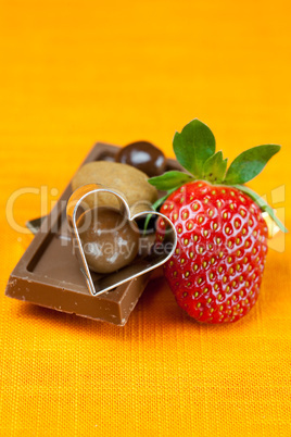 chocolate bars, strawberry, heart and the candy on the orange fa