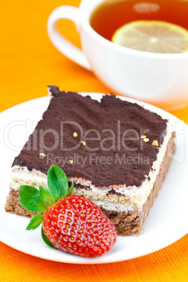 lemon tea, cake and strawberries lying on the orange fabric