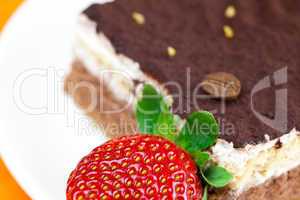 cake on a plate and strawberries lying on the orange fabric