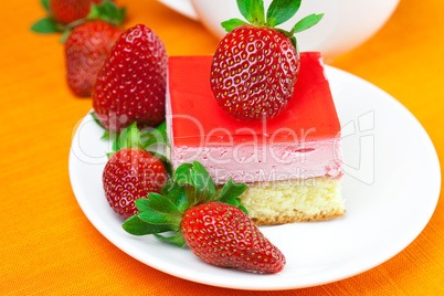 lemon tea, cake and strawberries lying on the orange fabric