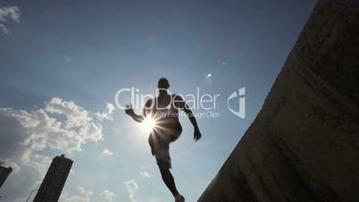 Friends jumping off a wall in Havana, Cuba