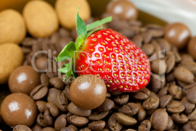strawberries lying on a background of coffee beans, cinnamon and