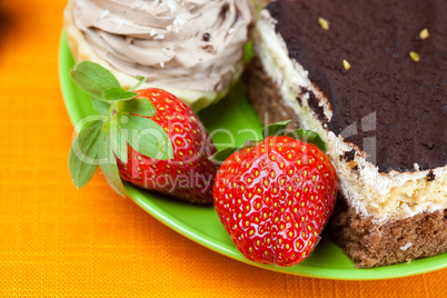 cake and strawberries lying on the orange fabric