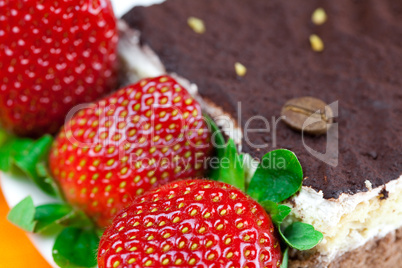 cake on a plate and strawberries lying on the orange fabric