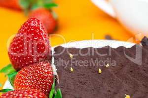 cake on a plate and strawberries lying on the orange fabric